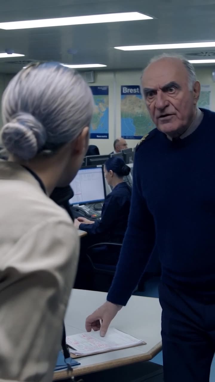 Commander Marc abruptly seizes the clipboard from the desk in visible disbelief.