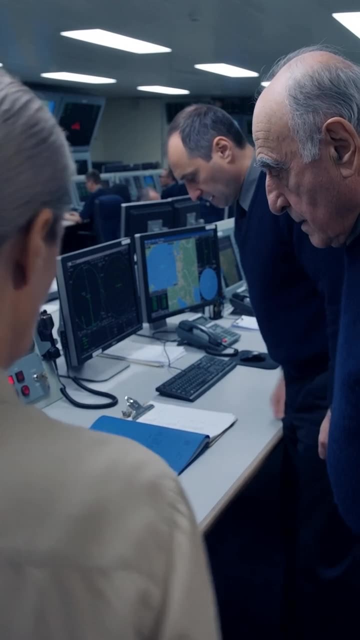 Julien sets down the radio handset with a bowed head beside an attentive Marc.