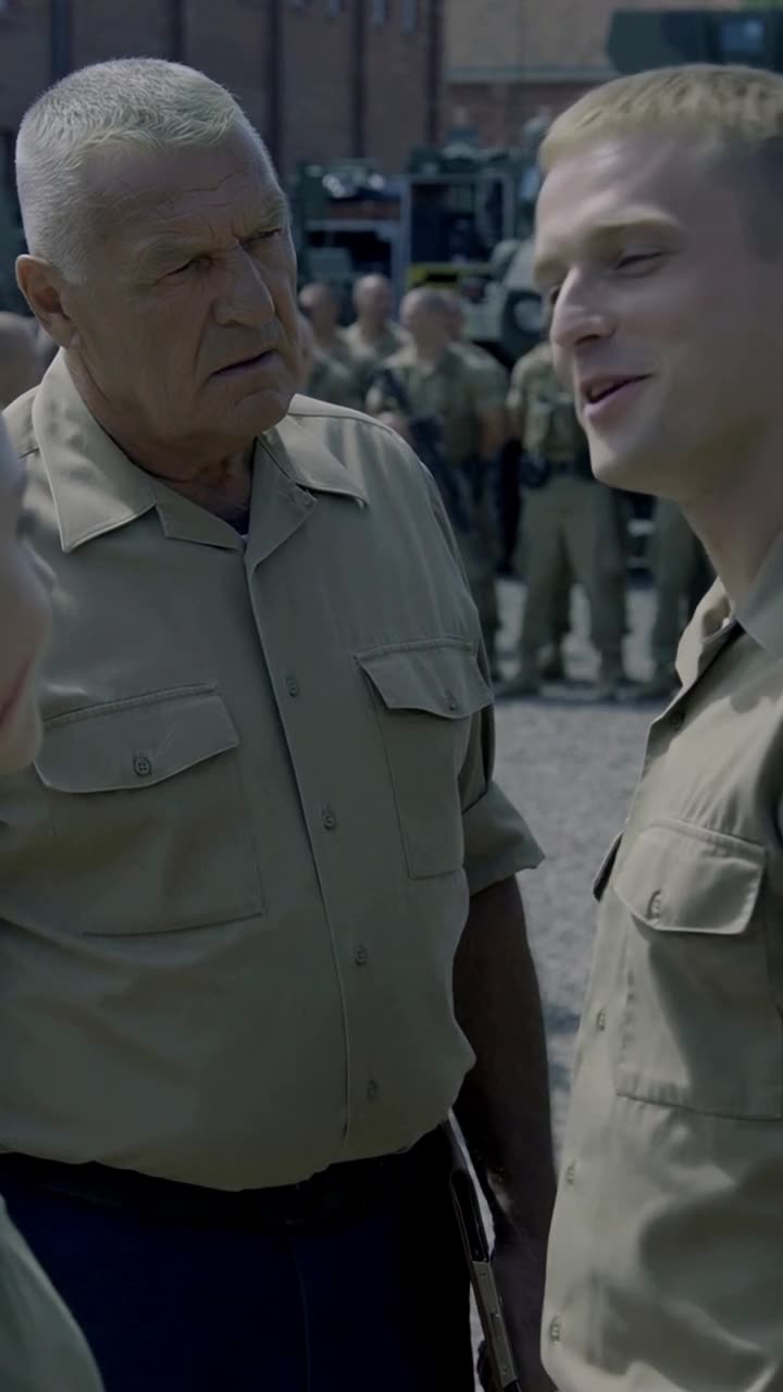 Julien smirks smugly as he gestures toward Camille to report insubordination to the commander.