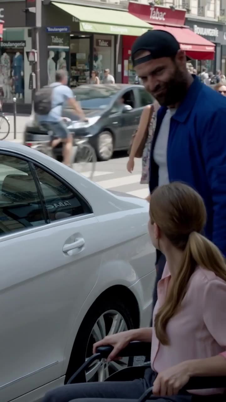 The bearded aggressor sneers as he eyes the unlocked luxury car parked on the busy Parisian street.
