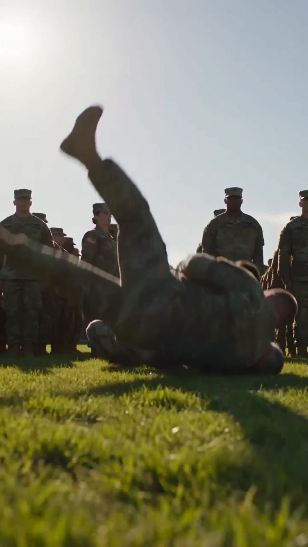 A soldier crashes onto the grass during a dramatic takedown in front of the regiment.