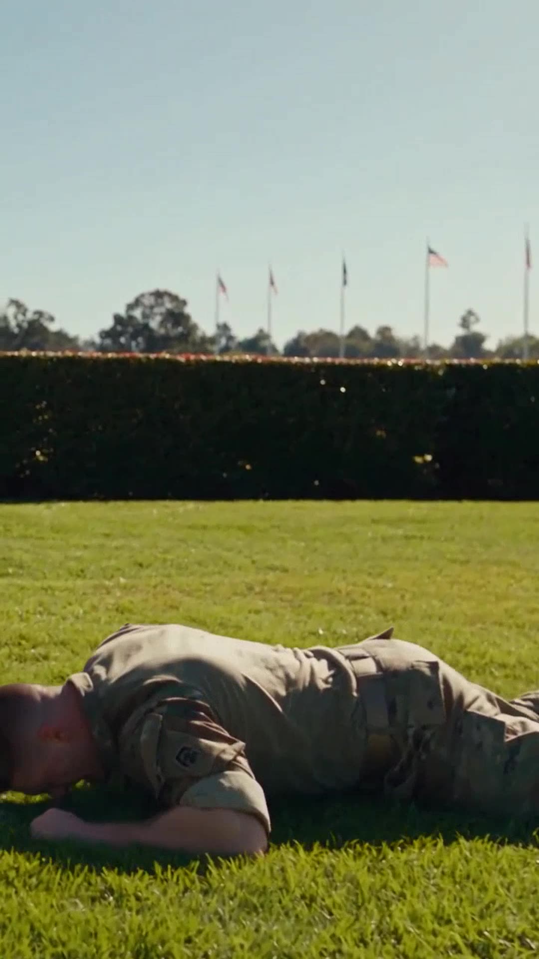 Sergeant Ryan Novak lies flat and defeated on the green grass after being thrown.