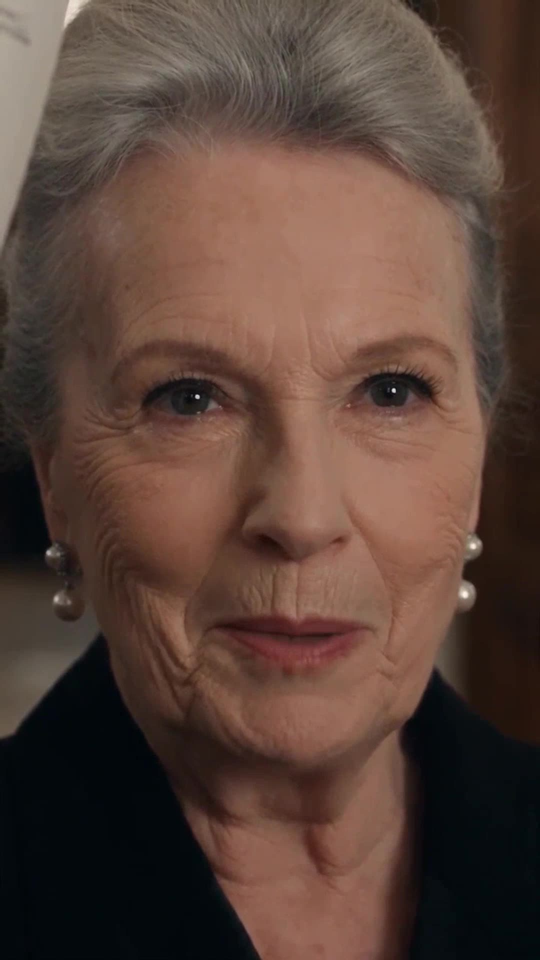 Hélène smiling coldly with piercing eyes as she confronts Philippe
