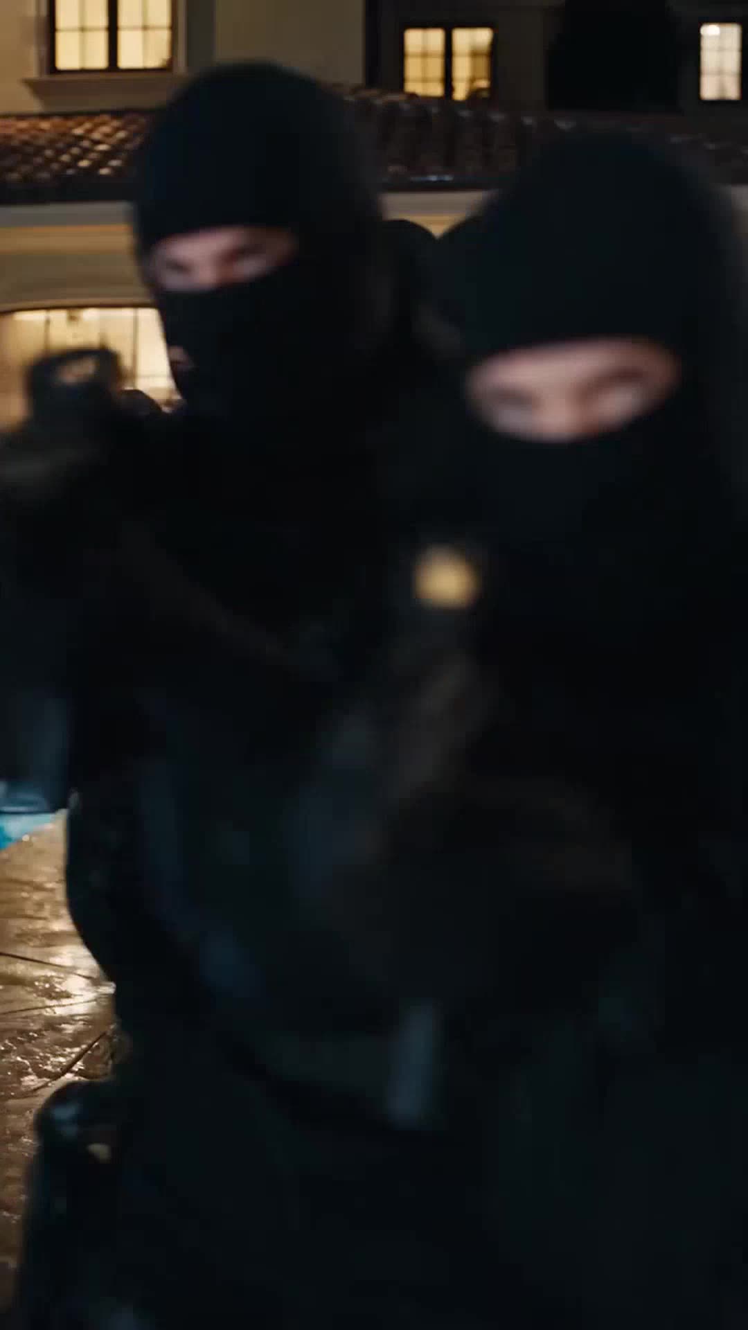 Armed tactical security guards in black balaclavas sweep the estate patio